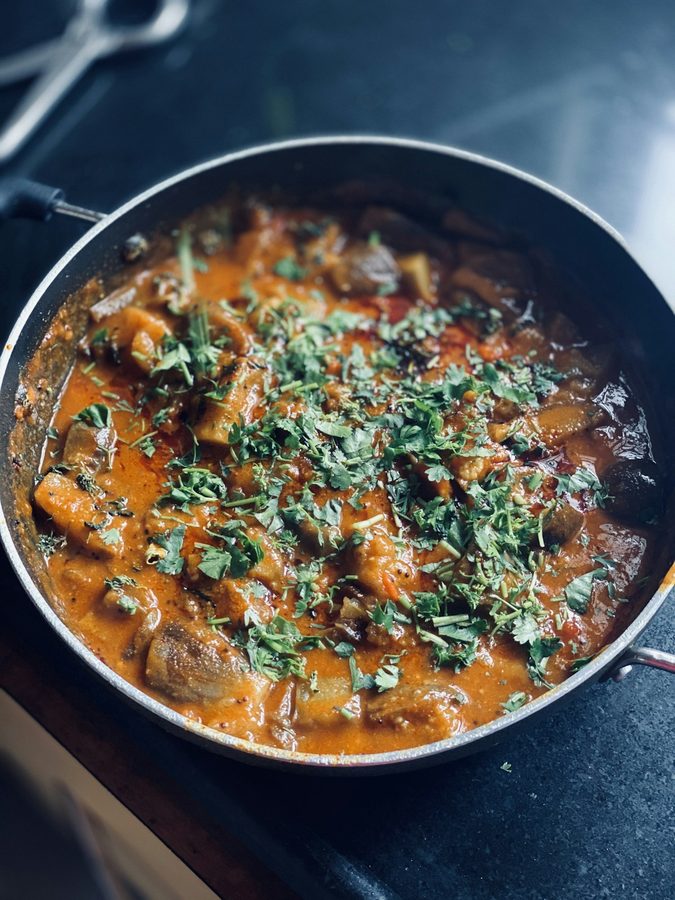 Slow-cooked goat karahi curry finished with fresh coriander at Leduc Meat & Grill