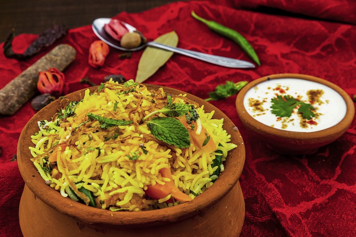 Biryani served in a clay pot with raita — lamb, chicken and goat biryani at Leduc Meat & Grill